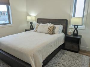 特拉弗斯城Downtown Traverse City Capri Condo 316的一间卧室配有一张带两盏灯和地毯的床。