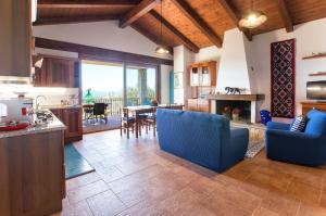 阿尔盖罗Brassol Casa Vacanze Vista Mare的厨房以及带蓝色椅子和桌子的客厅。