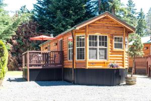 帕克斯维尔Riverbend Cottage & RV Resort的小木屋设有阳台和遮阳伞