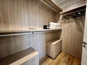 米兰NEW WONDERFUL BILO WITH WALK-IN CLOSET from Moscova Suites Apartments的步入式衣柜,配有木墙和木地板