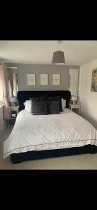 Seacroft2 bedroom house的卧室配有一张带白色床单和枕头的大床。