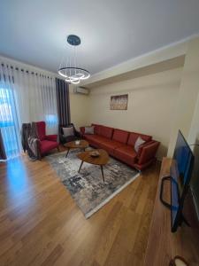 斯库台Anoe City Center Apartment的客厅配有红色沙发和电视