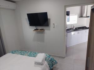 努尔德Apricity Suites Aruba的白色的房间,墙上配有电视