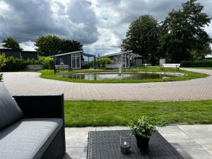 LathumFerienhaus / Chalet / Bungalow am See, Holland, Niederlande, Lathum的中间有一个设有长椅和池塘的公园