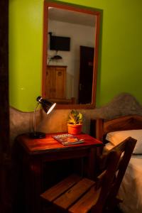 韦尔卡鲍普萨达塔图菲利兹酒店的一间卧室配有带台灯和镜子的桌子