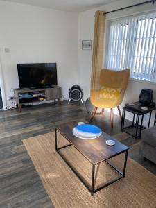 斯旺西44 Gower holiday village Ty Gŵyr Cosy 2 bedroom Chalet的客厅配有咖啡桌和电视