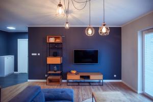 克维曾Apartament Słoneczny的客厅设有蓝色墙壁和电视。