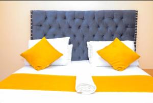 KisiiNuri Homes的一张带黄色枕头和蓝色床头板的床