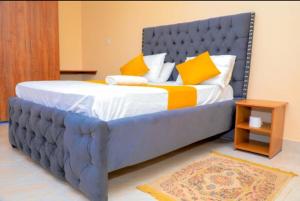 KisiiNuri Homes的一张大床,上面有黄色和白色的枕头