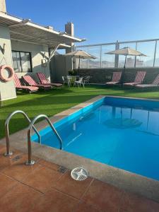 安托法加斯塔佛罗伦萨套房公寓酒店的一个带椅子的庭院里的一个大型蓝色游泳池