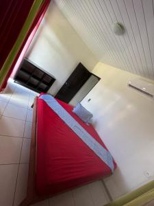 努库希瓦Taiohae Bay的一间在房间内配有红色床的卧室