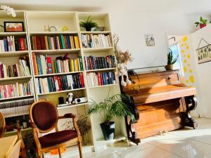 科隆布Une chambre chez moi,A guest room in my home,20mins to Paris的书架上摆放着钢琴旁边的书