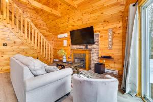 White HavenLakefront Cabin with Hot Tub 6 Mi to Ski Resort!的客厅配有两把椅子和壁炉