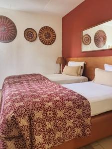 阿比让马尔利酒店的红色墙壁的酒店客房内的两张床