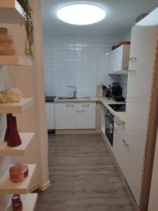 哥德堡Göteborgs Pärla nr 2的小厨房配有白色橱柜和水槽
