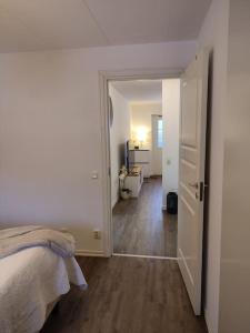 哥德堡Göteborgs Pärla nr 2的一间白色卧室,配有一张床和一个走廊