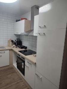 哥德堡Göteborgs Pärla nr 2的白色的厨房设有水槽和炉灶。