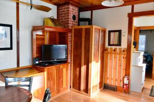 班夫Banff Beaver Cabins的客厅配有木柜上的电视