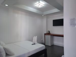 长滩岛MGG CASA DELA PLAYA的白色的客房配有床和电视