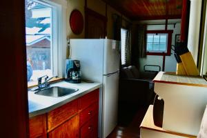 班夫Banff Beaver Cabins的厨房配有水槽和冰箱