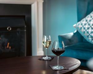 伦敦伦敦希尔顿逸林酒店 - 港口河畔的木桌旁放两杯葡萄酒