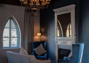 伦敦伦敦希尔顿逸林酒店 - 港口河畔的客厅配有蓝色椅子和镜子