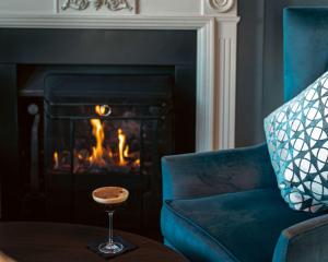 伦敦伦敦希尔顿逸林酒店 - 港口河畔的客厅设有蓝椅和壁炉