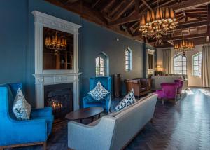 伦敦伦敦希尔顿逸林酒店 - 港口河畔的客厅配有蓝色椅子和壁炉