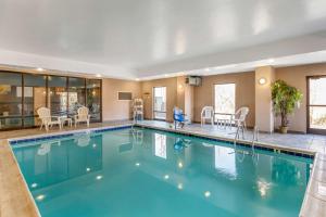 BurlingtonComfort Suites South Point - Huntington的游泳池位于酒店客房内,配有桌椅