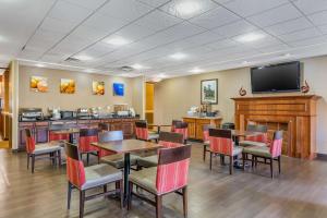 BurlingtonComfort Suites South Point - Huntington的餐厅设有桌椅和平面电视。