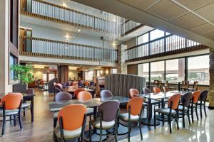 圣安东尼奥Drury Plaza Hotel San Antonio Airport的大楼内带桌椅的餐厅