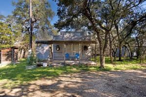 圣马科斯A Quaint Countryside Tiny Home - Outhouse & Outdoor Shower Included的院子内带两把蓝色椅子的小房子