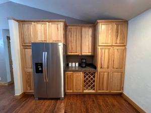 ThayneLodge on the Green的厨房配有不锈钢冰箱和木制橱柜