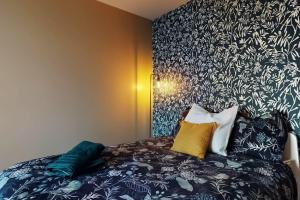 诺伊斯·勒·格兰德Proche Disney & Paris-2 min gare的一间卧室配有一张带黑白色图案墙壁的床