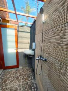 珀尼达岛Maskot Penida Cottage的带淋浴和盥洗盆的浴室