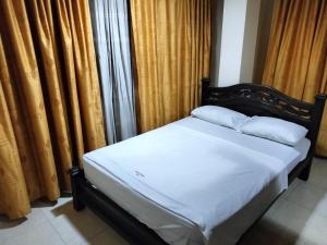 比利亚维哈Merkezi Saray的配有窗帘的客房配有一张带两个枕头的床