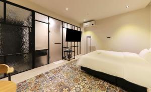 YangsanDen Basta hotel的卧室配有一张白色大床和电视。