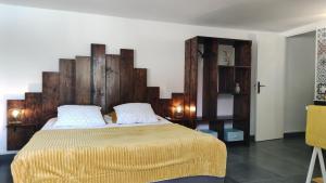 圣安尼Les Coulirooms - Gîte的一间卧室配有一张大床和木制床头板