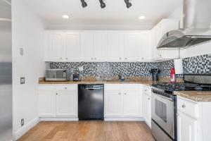 迈阿密海滩Perfect Beach Home For A Family Getaway Wpool!的厨房配有白色橱柜和黑色洗碗机
