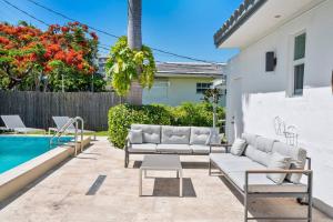 迈阿密海滩Perfect Beach Home For A Family Getaway Wpool!的游泳池旁带白色家具的庭院