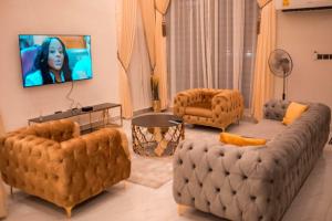 库马西Sleek Luxury Homes的客厅配有大沙发和两把椅子