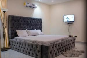 库马西Sleek Luxury Homes的一张大床,位于一个配有电视的房间