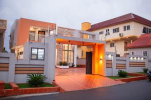 库马西Sleek Luxury Homes的前面有橙色入口的房子