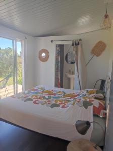 PaïtaChambres d'hôtes Tontouta Tamoa的一间卧室配有一张带彩色毯子的床
