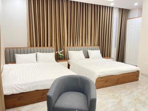 河仙Hà Hùng Panorama Hotel的配有椅子和椅子的客房内的两张床