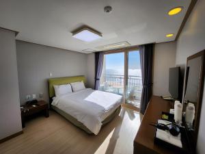 保宁市Mud Beach Hotel的一间卧室配有一张床,享有海景