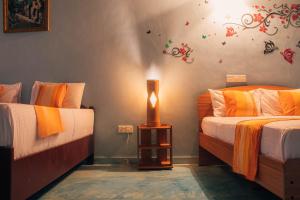 阿鲁甘湾Shell Resort的一间卧室设有两张床和一张桌子上的台灯。