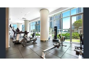 黄金海岸2-Bed Apt in Surfers Paradise with Pools and Gym的带有氧器材的健身房,位于带窗户的大楼内