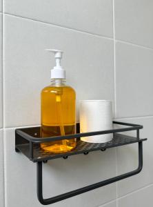 波德申Fourteen Homestay的浴室内黑色架子上的肥皂分配器