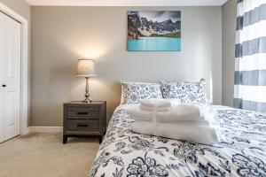 埃德蒙顿Lux-Rooms in Allard Edmonton的一间卧室配有一张带灯的蓝色和白色的床